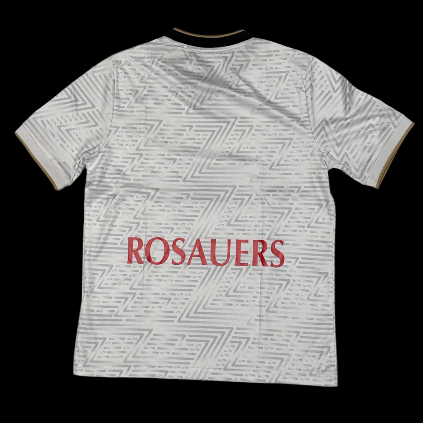 Back of a white soccer jersey with a silver repeated "Z" gradient pattern and a red "Rosauers"