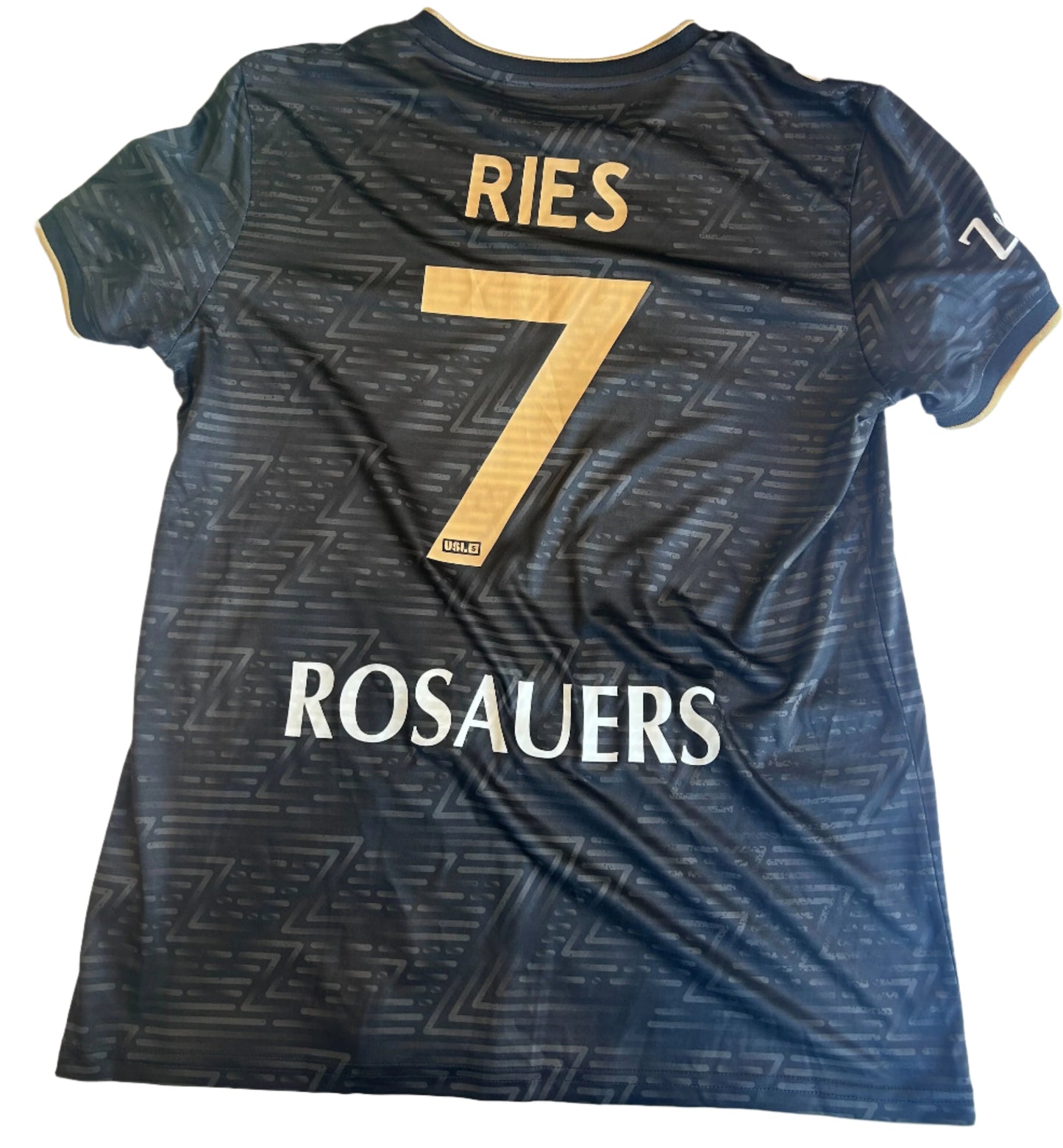 Black sports jersey with 'RIES' and number '7' on a white surface