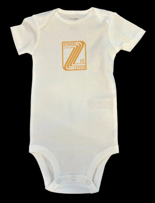 White baby onesie with a gold Zephyr crest