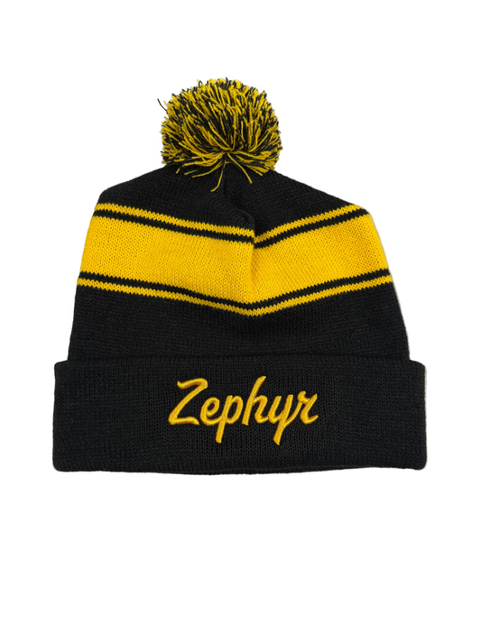 Black and yellow striped beanie with pom-pom on a white background