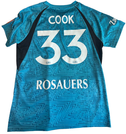 Blue sports jersey with 'Cook 33 Rosauers' printed on a white surface
